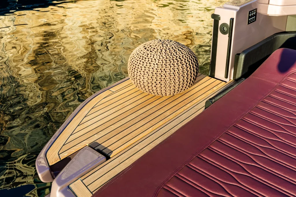 Dettaglio della zona poppa del Cranchi A32 Luxury Tender: coperta in teak e finiture outdoor con pouf di design.