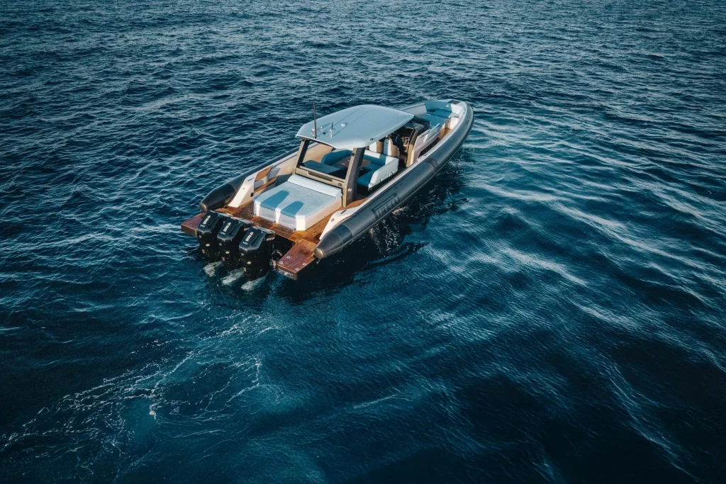 Pirelli 47 Speedboats: foto aerea di poppa con tre fuoribordo e piattaforme bagno, in mare con costa sullo sfondo.