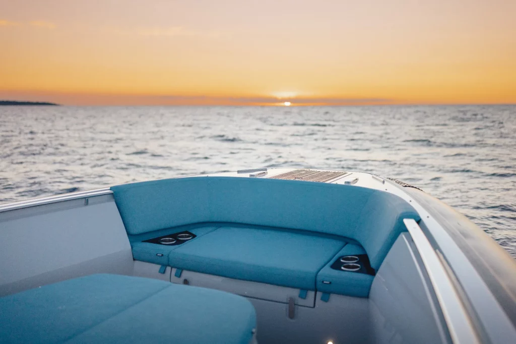 Pirelli 47 Speedboats: area prendisole di prua con lounge e portabicchieri, sullo sfondo il tramonto in mare.