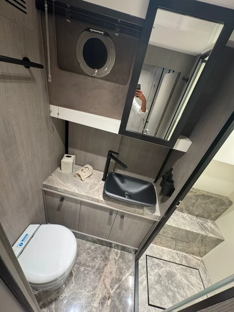 Bagno del Saxdor 400 GTS con piano effetto marmo, lavabo nero e WC, design moderno e materiali di qualità.