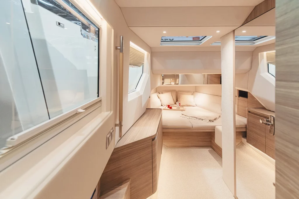 Cabina di prua del Saxdor 460 GTC con letto matrimoniale, luci LED e skylight, arredi in tonalità chiare.