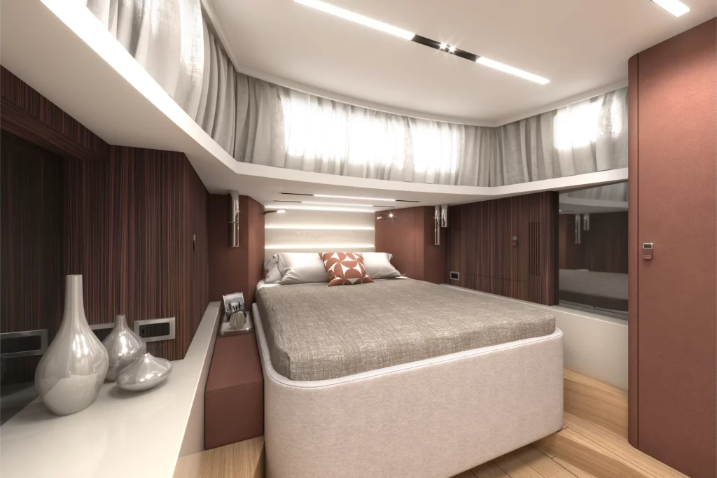 Cabina matrimoniale del Cranchi A47 con ampio letto, rivestimenti in tessuto, dettagli in legno e illuminazione lineare integrata.